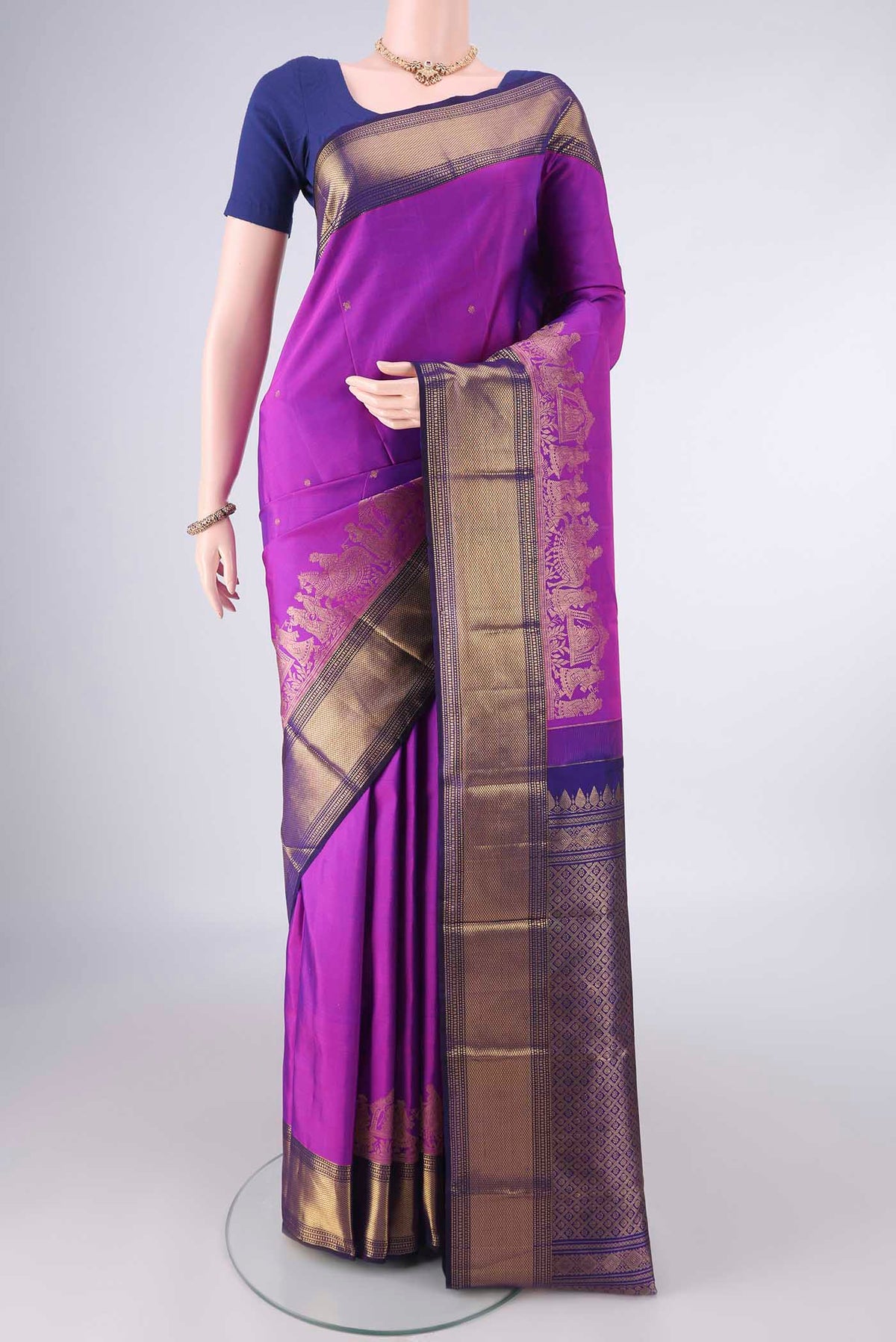 Pure Silk Magenta Kanjivaram Saree with Zari Butta on the body and Zari Border.  displayed on a mannequin
