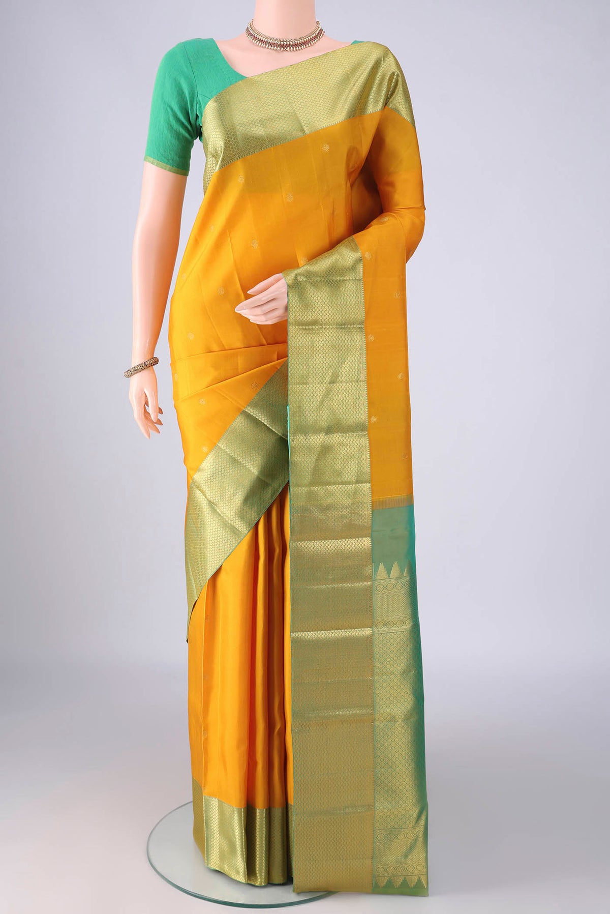 Pure Silk Mustard Kanchipuram Saree with Zari Butta on the body and Zari Border.  displayed on a mannequin