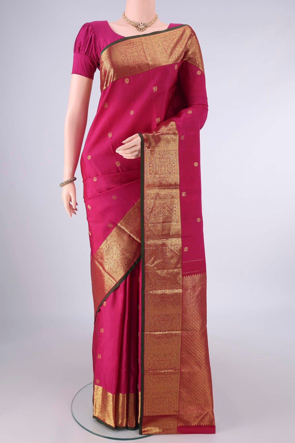 Pure Silk Rani Pink Kanchipuram Saree with Zari Butta on the body and Zari Border.  displayed on a mannequin