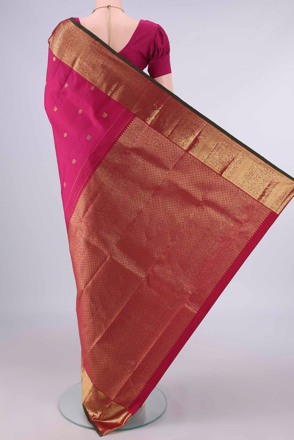 Flat view of Pure Silk Rani Pink Kanchipuram Saree with Zari Butta on the body and Zari Border. 