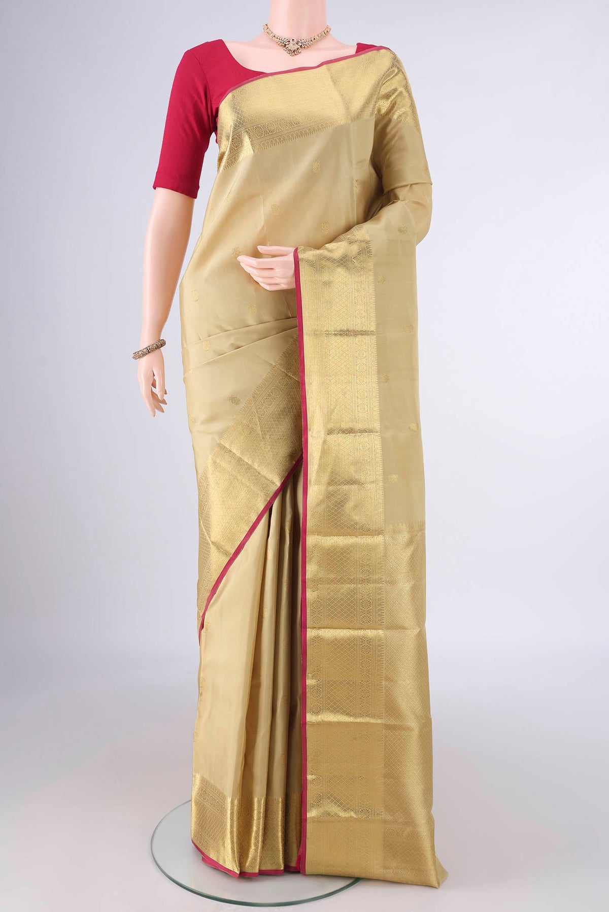Pure Silk Dark Beige Kanchipuram Saree with Zari Butta on the body and Zari Border.  displayed on a mannequin