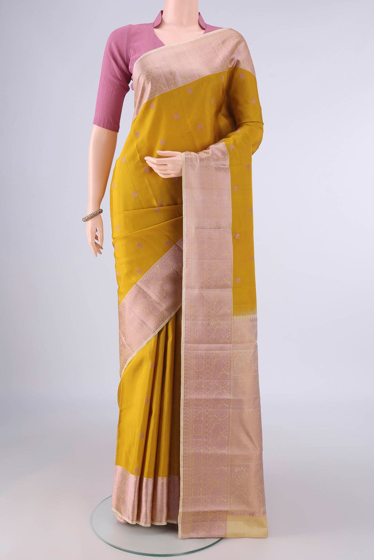 Pure Silk Mustard Kanchipuram Saree with Thread Butta on the body and Thread Border.  displayed on a mannequin