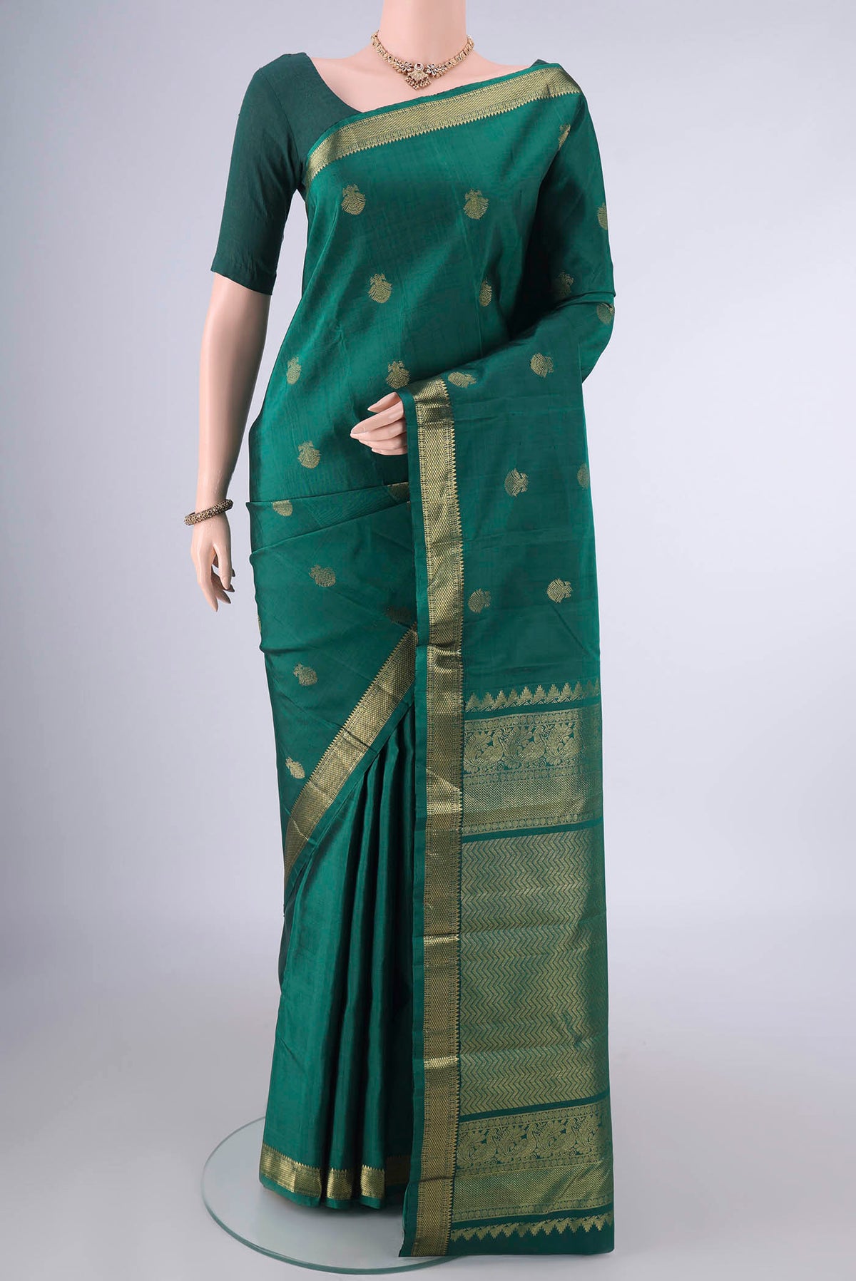 Pure Silk Green Kanchipuram Saree with Zari Butta on the body and Zari Border.  displayed on a mannequin