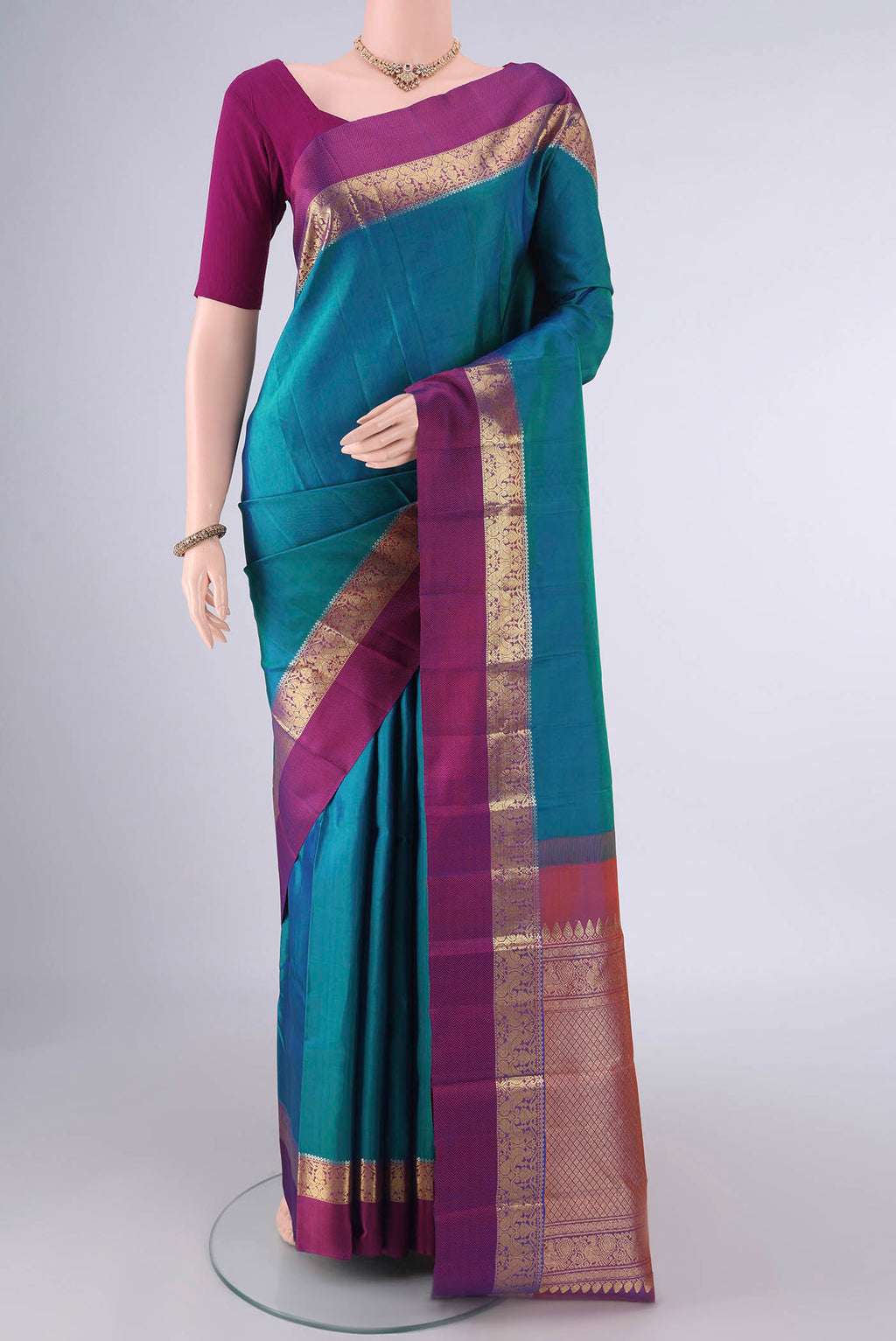 Pure Silk Sea Green Kanchipuram Saree with Plain Body and Zari And Thread Border.  displayed on a mannequin