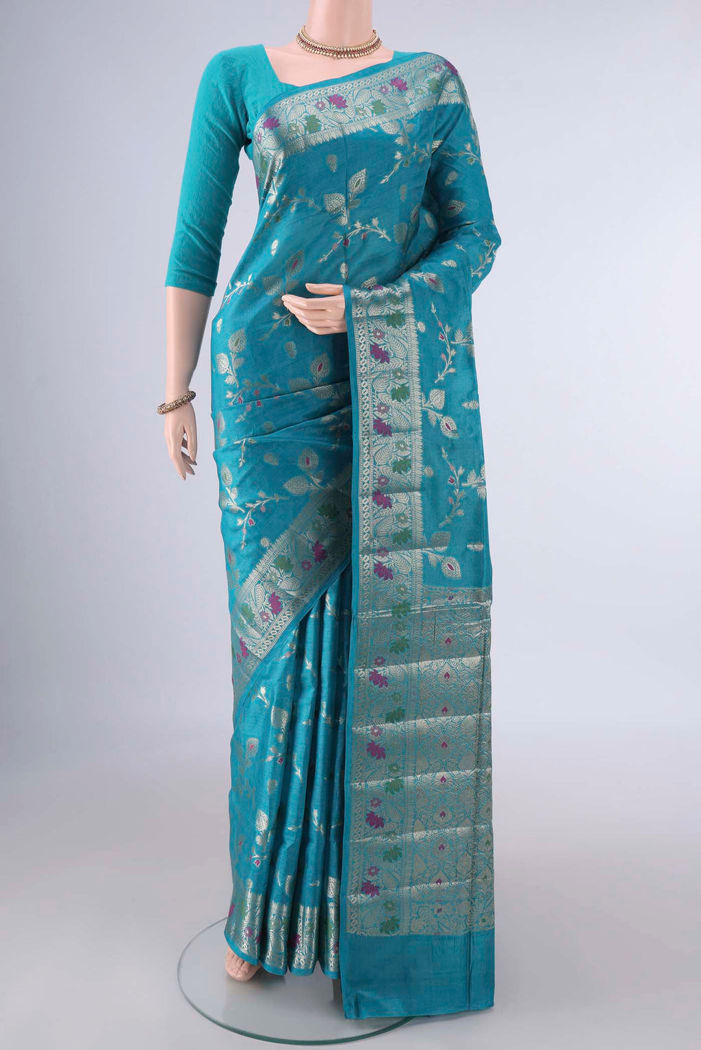 Turquoise Banarasi Tussar Saree with Zari And Thread Butta on the body and Zari Border.  displayed on a mannequin