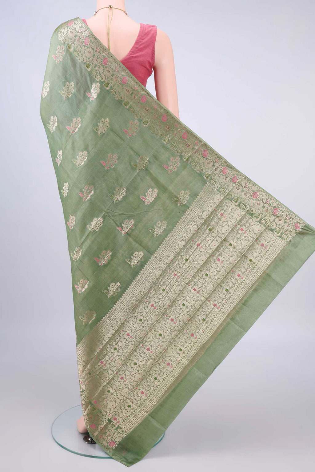 Flat view of Light Green Banarasi Tussar Saree with Zari And Thread Butta on the body and Zari Border. 
