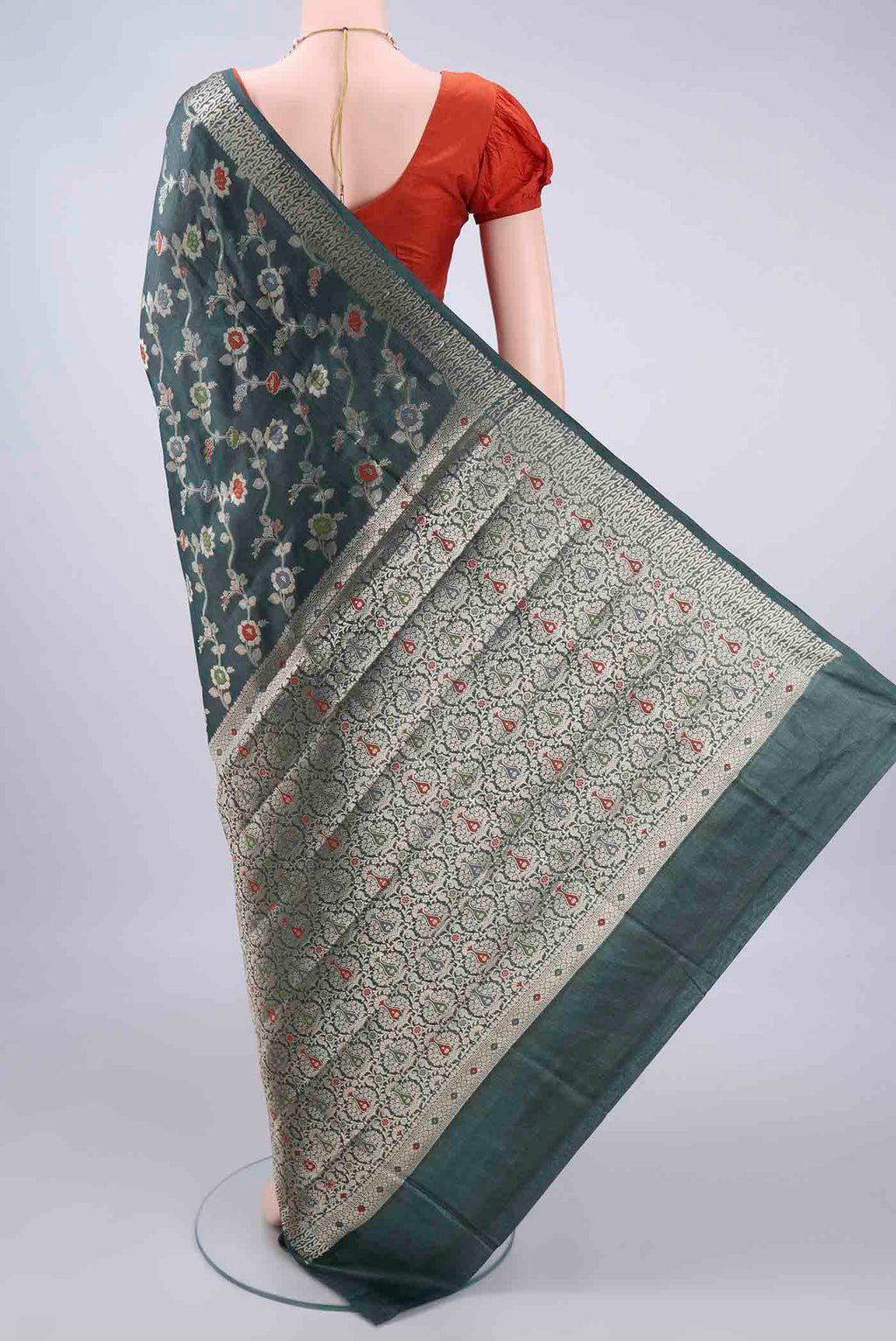 Flat view of Olive Green Banarasi Tussar Saree with Zari And Thread Butta on the body and Zari Border. 
