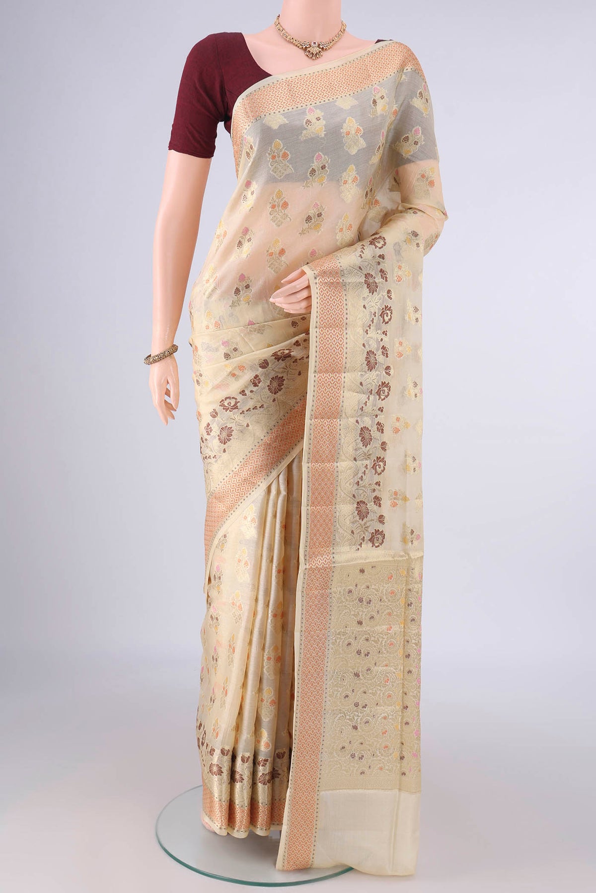 Cream Banarasi Tussar Saree with Zari And Thread Butta on the body and Zari Border.  displayed on a mannequin