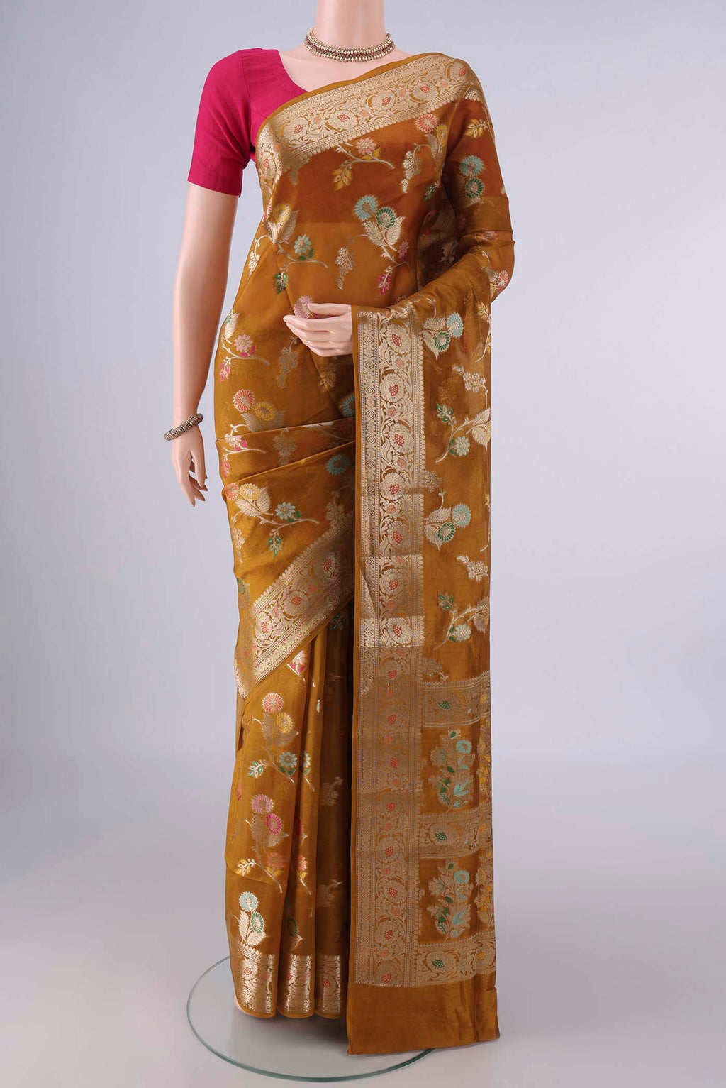 Pure Silk Mustard Banarasi Raw Saree with Zari And Thread Butta on the body and Zari Border.  displayed on a mannequin