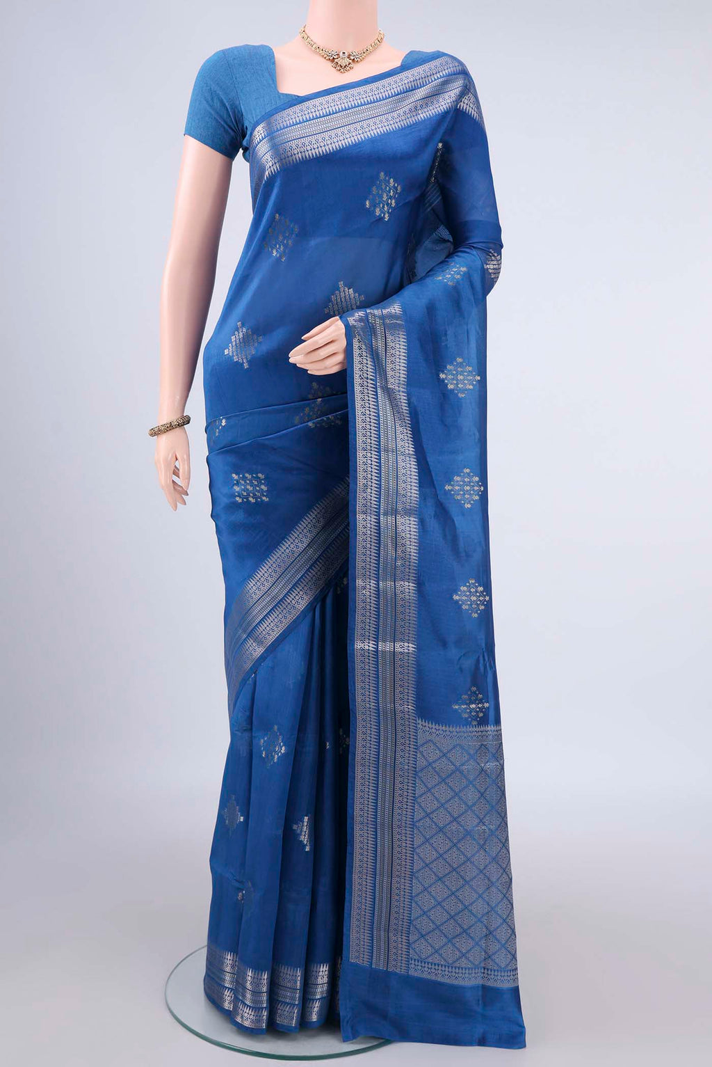 Pure Silk Royal Blue Banarasi Raw Saree with Zari And Thread Butta on the body and Zari Border.  displayed on a mannequin