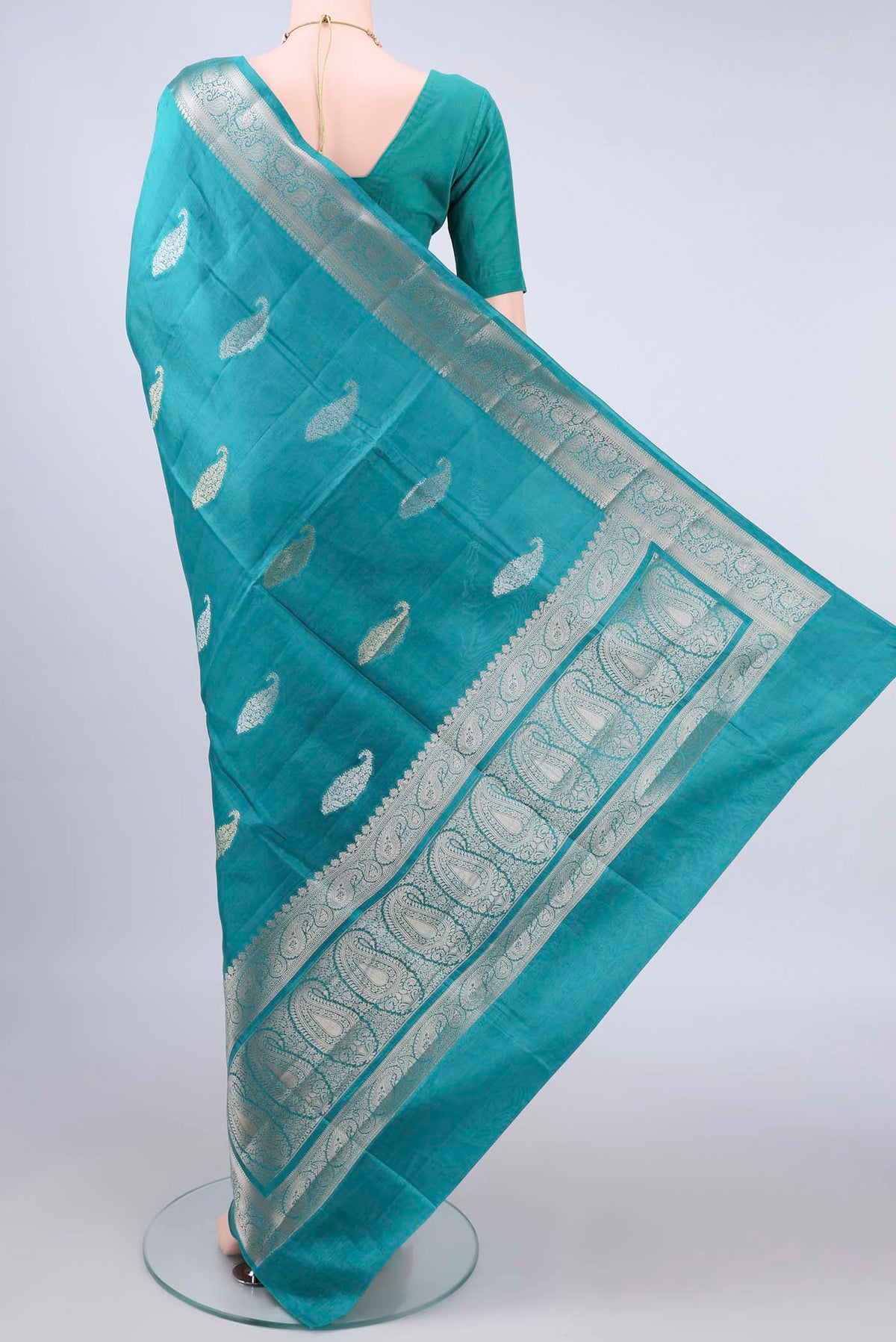 Flat view of Pure Silk Sea Green Banarasi Raw Saree with Zari And Thread Butta on the body and Zari Border. 