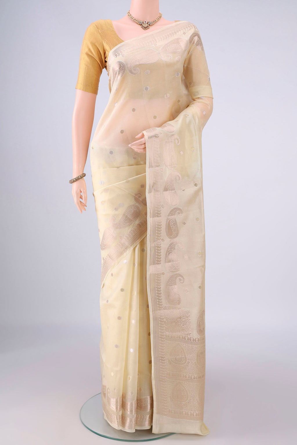 Pure Silk Cream Banarasi Raw Saree with Zari Butta on the body and Zari Border.  displayed on a mannequin