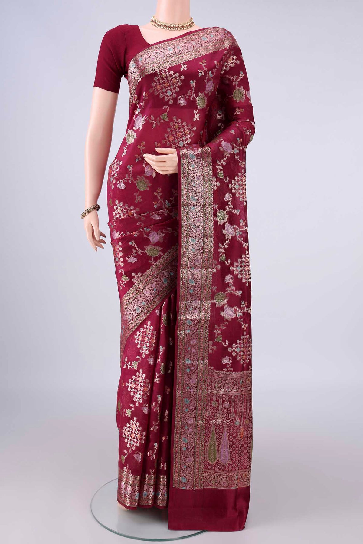 Pure Silk Maroon Banarasi Raw Saree with Zari Brocade on the body and Zari Border.  displayed on a mannequin