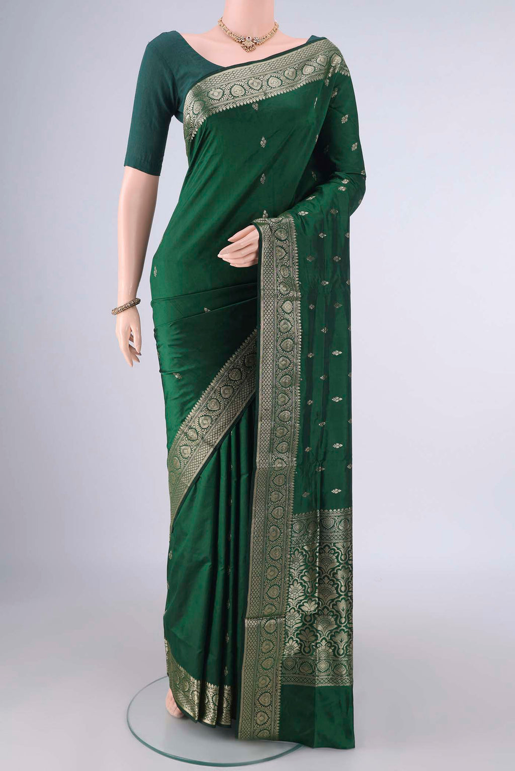 Pure Silk Bottle Green Banarasi Katan Saree with Zari Butta on the body and Zari Border.  displayed on a mannequin