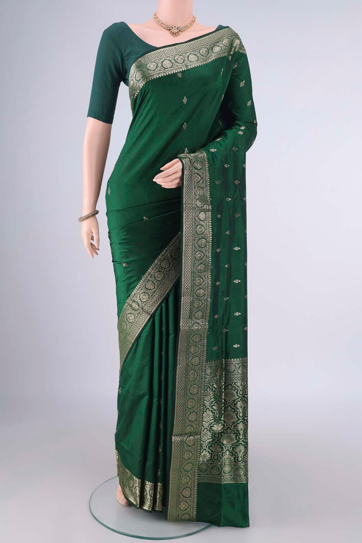 Pure Silk Bottle Green Banarasi Katan Saree with Zari Butta on the body and Zari Border.  displayed on a mannequin