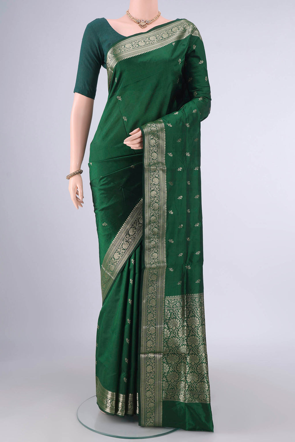Pure Silk Bottle Green Banarasi Katan Saree with Zari Butta on the body and Zari Border.  displayed on a mannequin