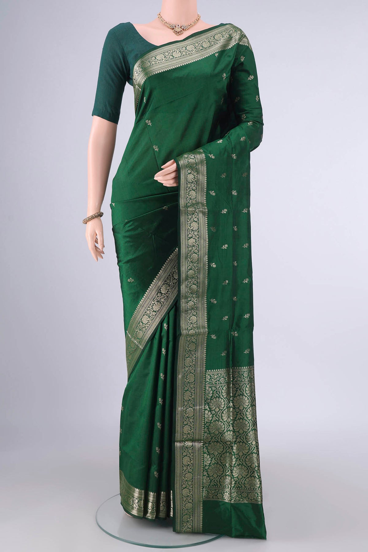 Pure Silk Bottle Green Banarasi Katan Saree with Zari Butta on the body and Zari Border.  displayed on a mannequin