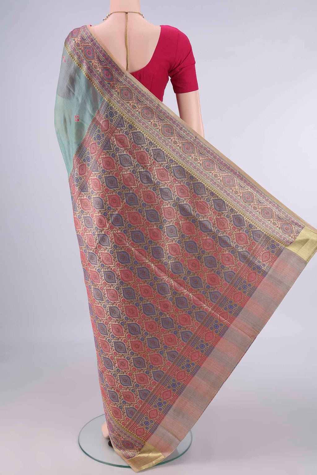 Flat view of Light Green Banarasi Tussar Saree with Embroidery on the body and Zari Border. 