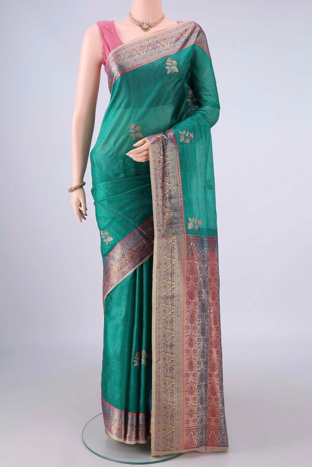 Sea Green Banarasi Tussar Saree with Embroidery on the body and Zari And Thread Border.  displayed on a mannequin