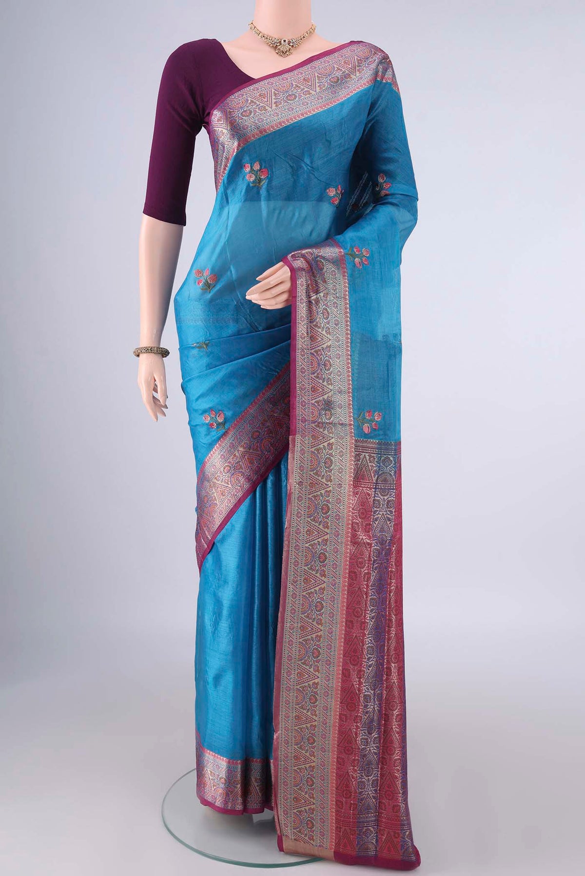 Blue Banarasi Tussar Saree with Embroidery on the body and Zari Border.  displayed on a mannequin