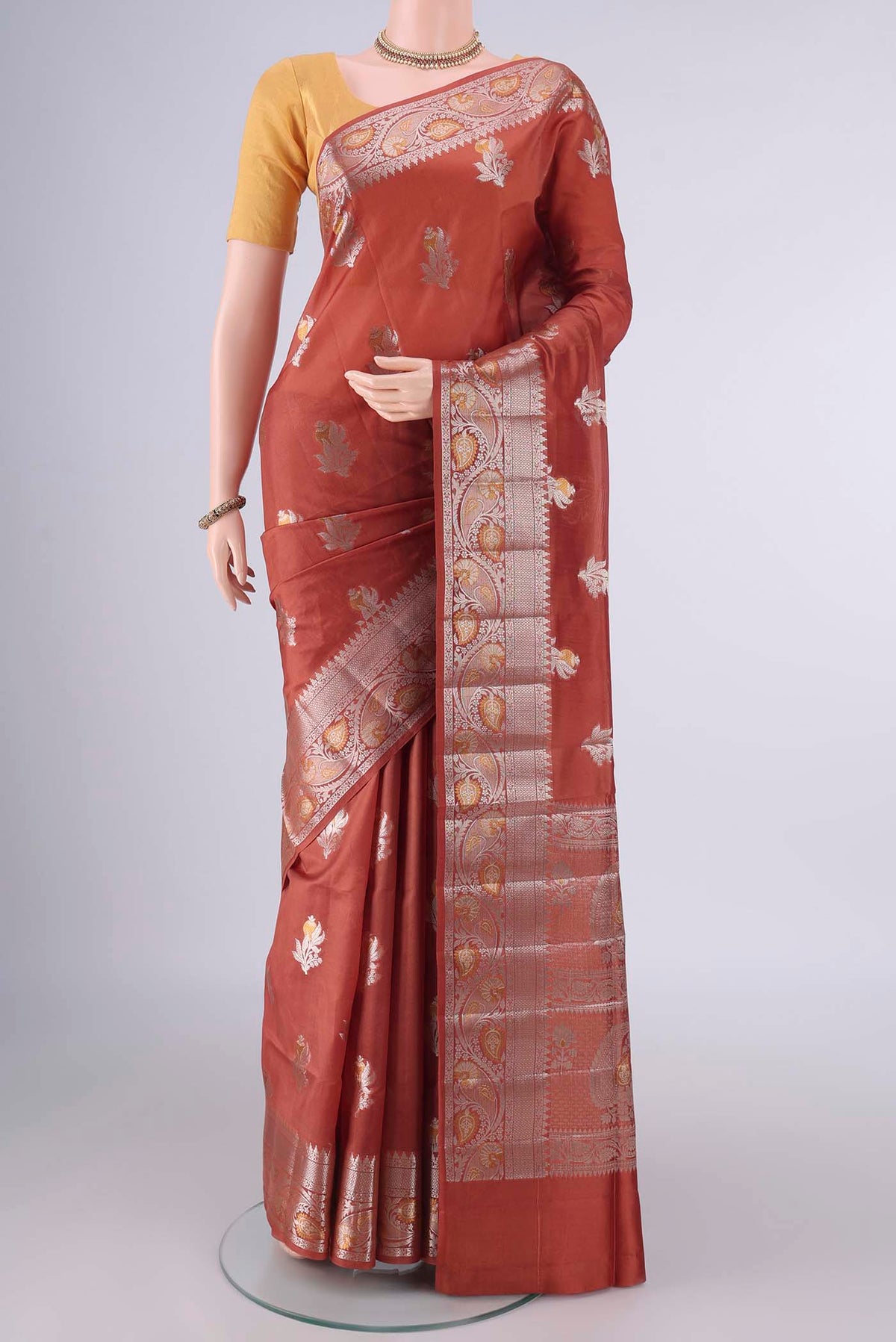 Pure Silk Rust Banarasi Raw Saree with Zari Butta on the body and Zari Border.  displayed on a mannequin