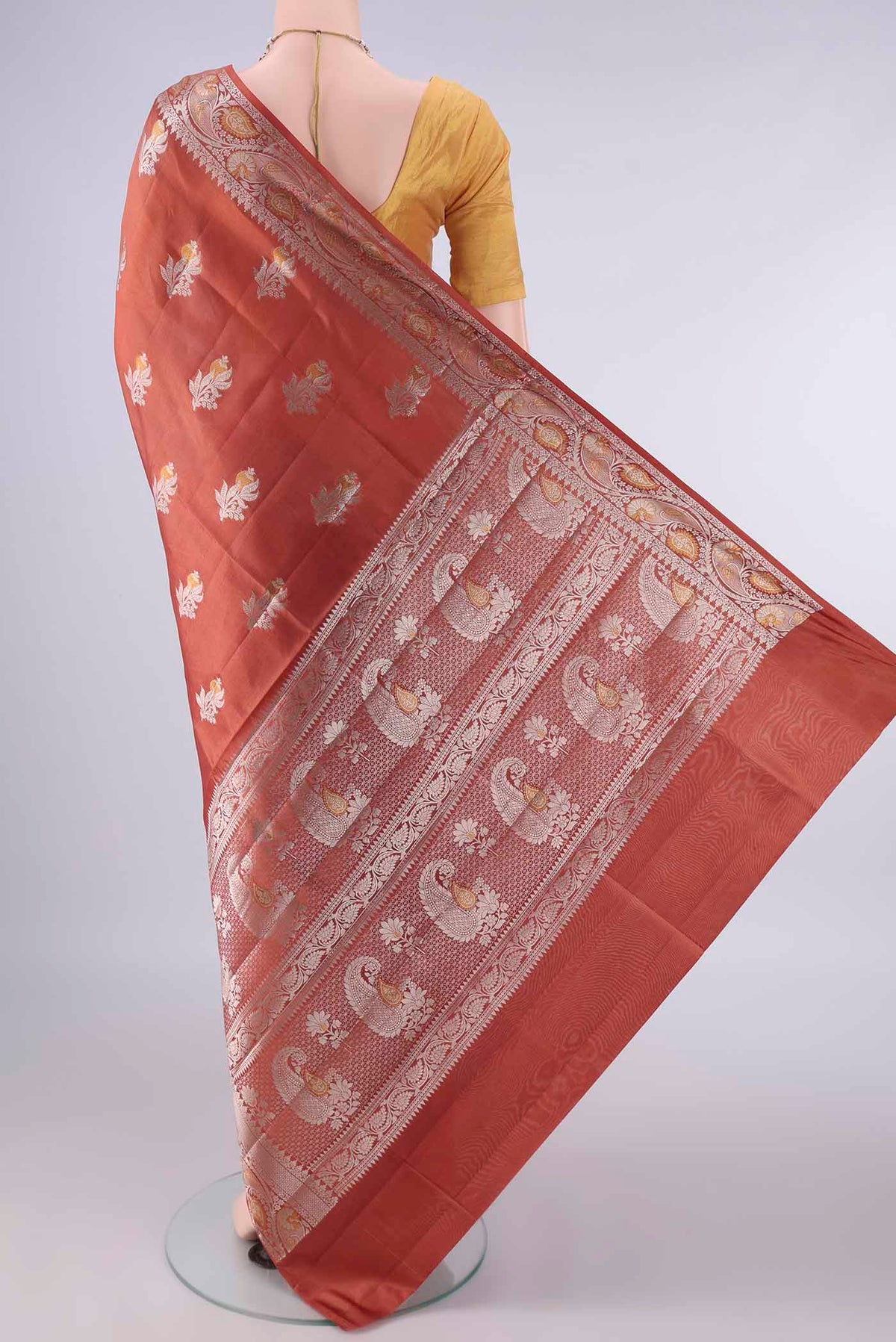 Flat view of Pure Silk Rust Banarasi Raw Saree with Zari Butta on the body and Zari Border. 