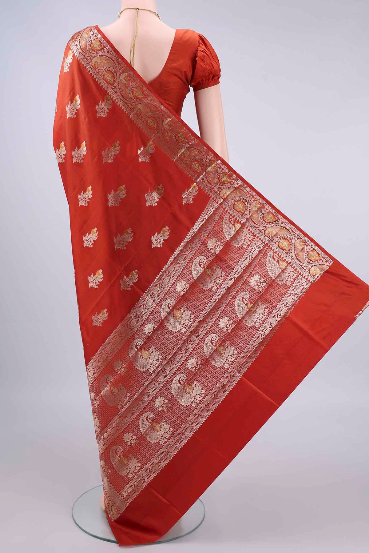 Flat view of Pure Silk Rust Banarasi Raw Saree with Zari And Thread Butta on the body and Zari Border. 