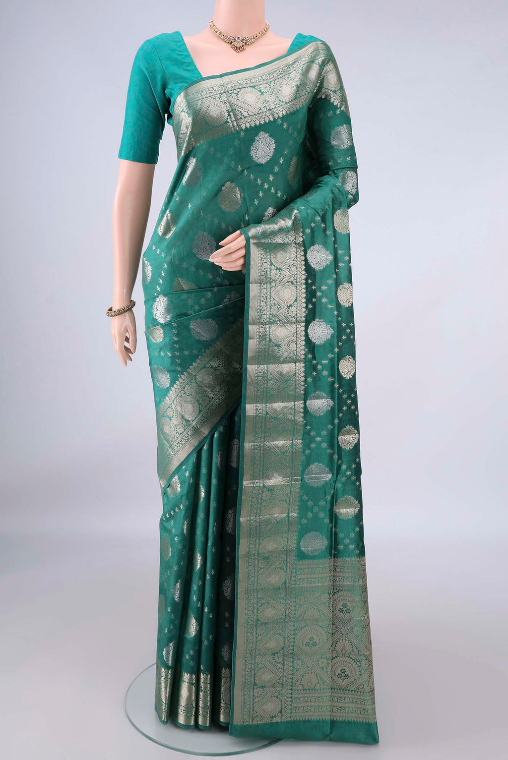 Pure Silk Green Banarasi Raw Saree with Zari Butta on the body and Zari And Thread Border.  displayed on a mannequin