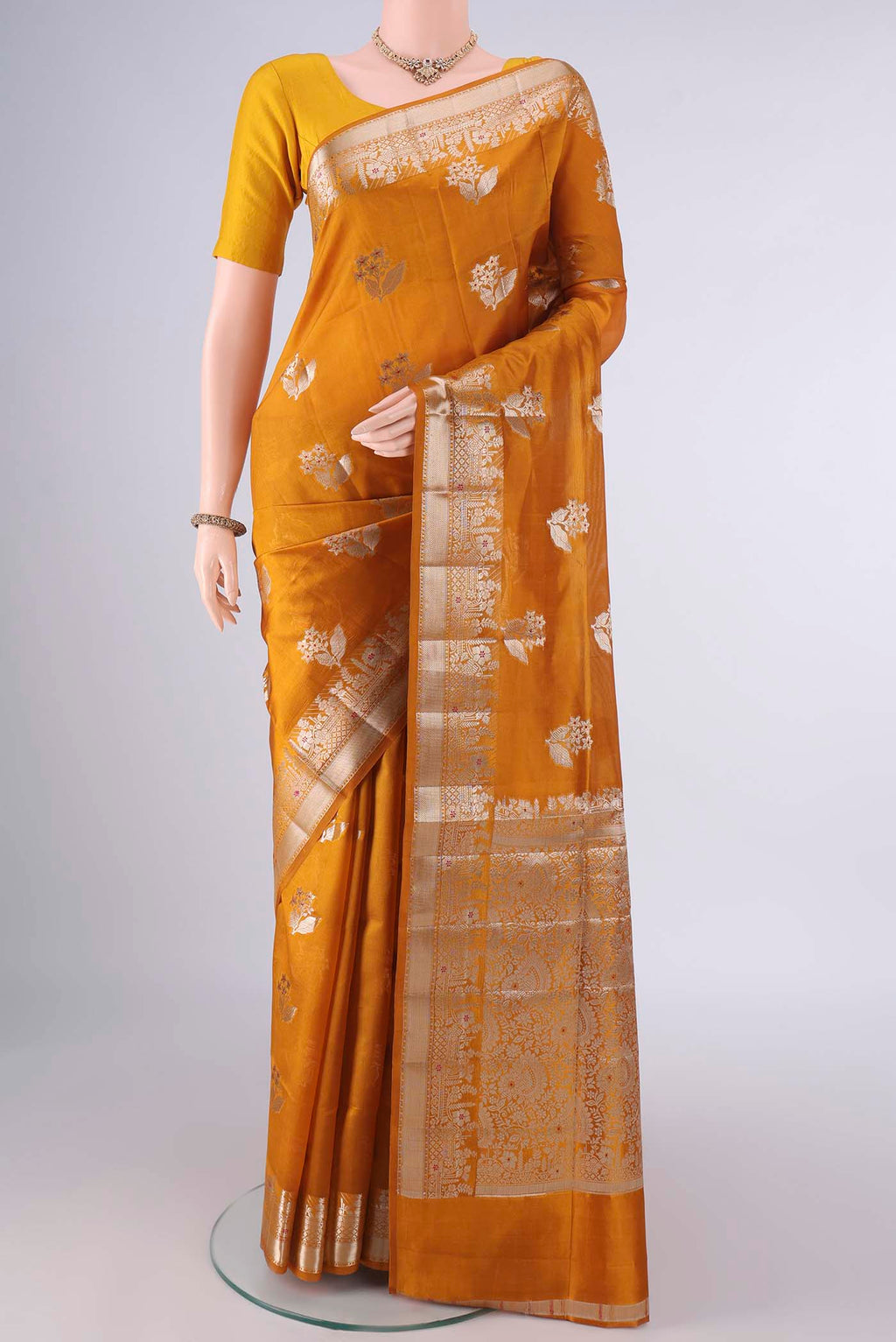 Pure Silk Mustard Banarasi Raw Saree with Zari And Thread Butta on the body and Zari Border.  displayed on a mannequin