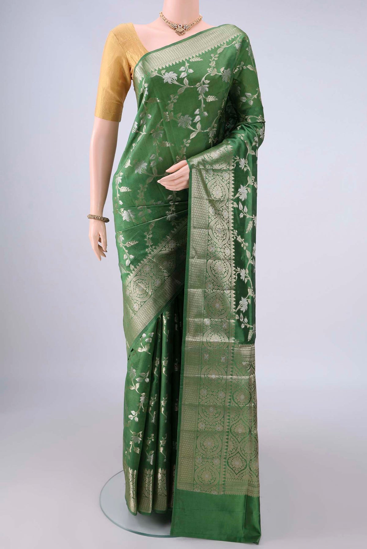 Pure Silk Green Banarasi Raw Saree with Zari Butta on the body and Zari Border.  displayed on a mannequin