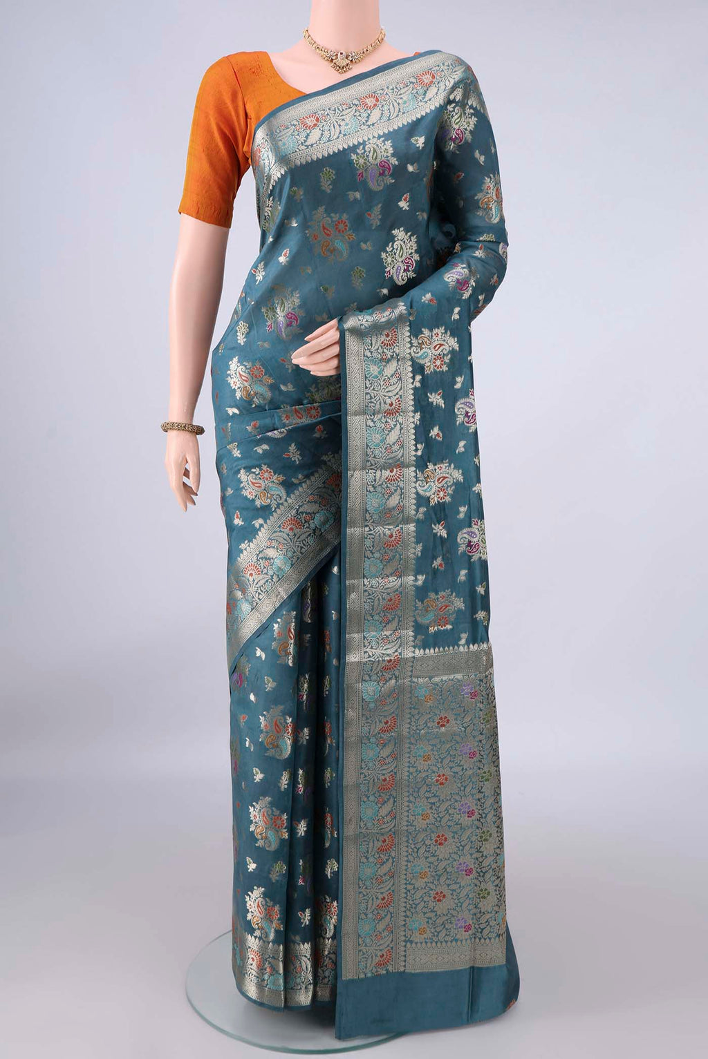 Pure Silk Maya Blue Banarasi Raw Saree with Zari And Thread Butta on the body and Zari And Thread Border.  displayed on a mannequin