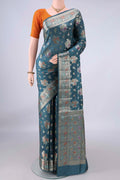 Pure Silk Maya Blue Banarasi Raw Saree with Zari And Thread Butta on the body and Zari And Thread Border.  displayed on a mannequin