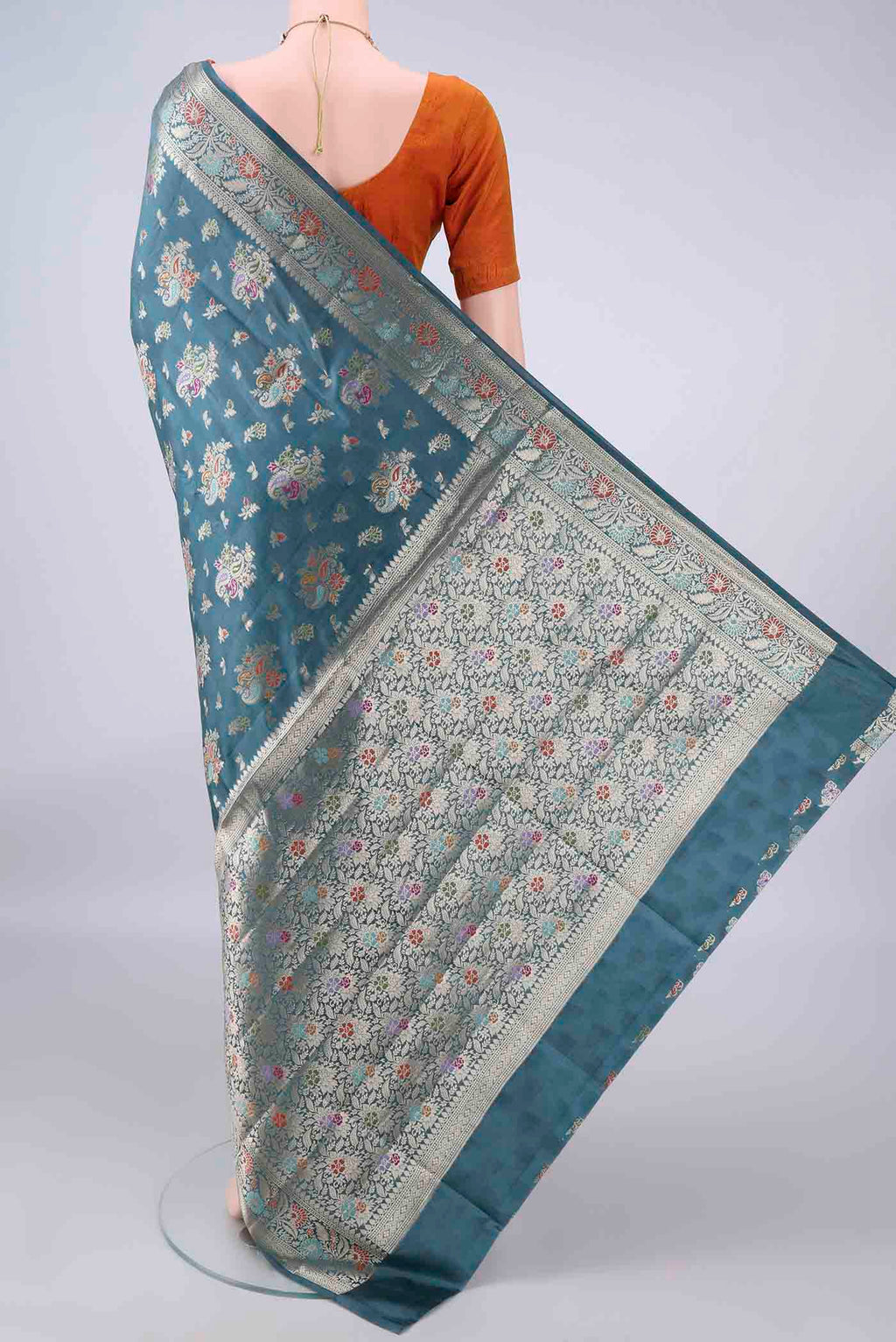 Flat view of Pure Silk Maya Blue Banarasi Raw Saree with Zari And Thread Butta on the body and Zari And Thread Border. 