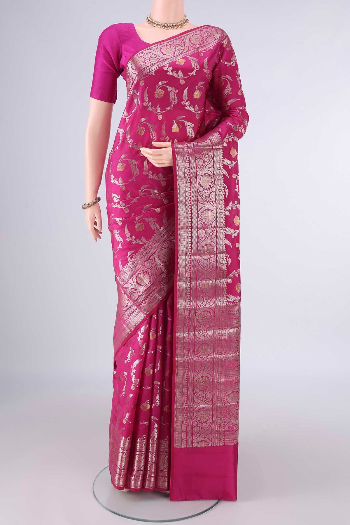 Pure Silk Rani Pink Banarasi Raw Saree with Zari And Thread Butta on the body and Zari Border.  displayed on a mannequin