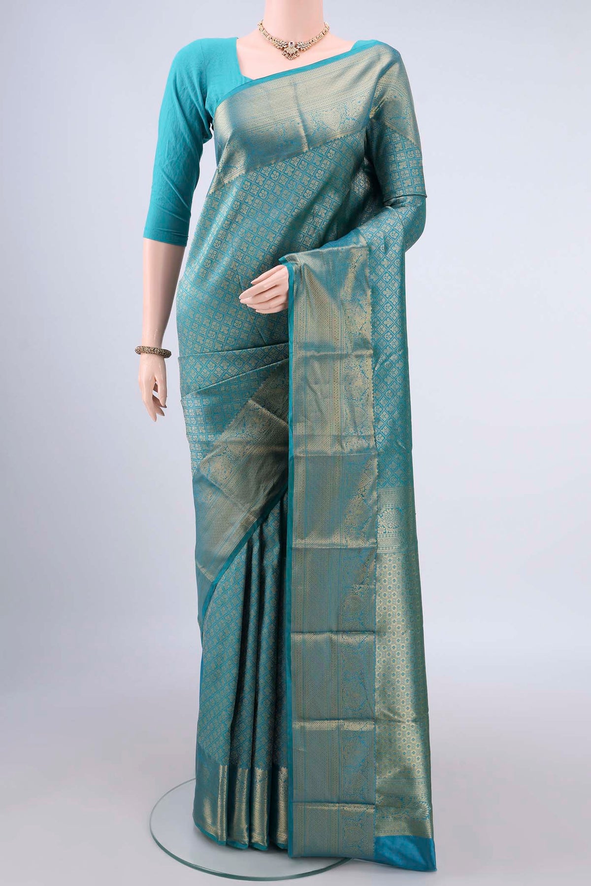 Pure Silk Sea Green Kanjivaram Saree with Zari Brocade on the body and Zari Border.  displayed on a mannequin