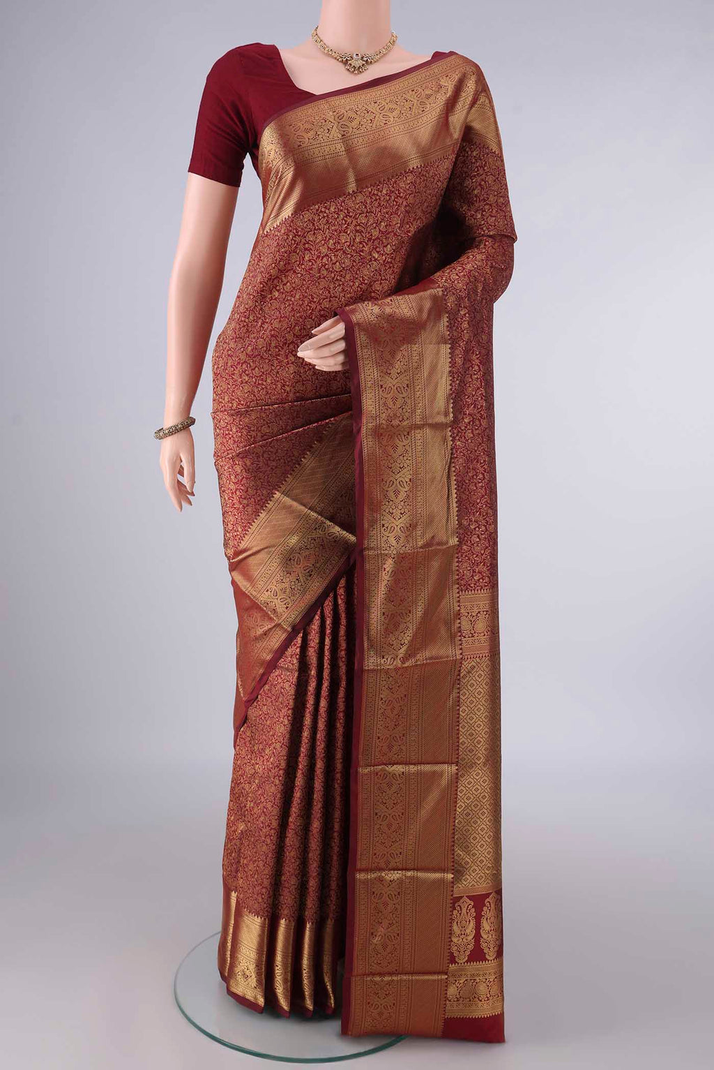 Pure Silk Maroon Kanjivaram Saree with Zari Brocade on the body and Zari Border.  displayed on a mannequin