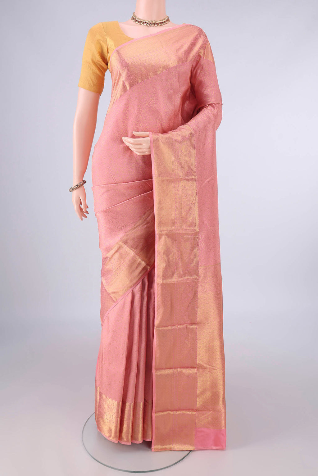 Pure Silk Peach Kanjivaram Saree with Zari Brocade on the body and Zari Border.  displayed on a mannequin