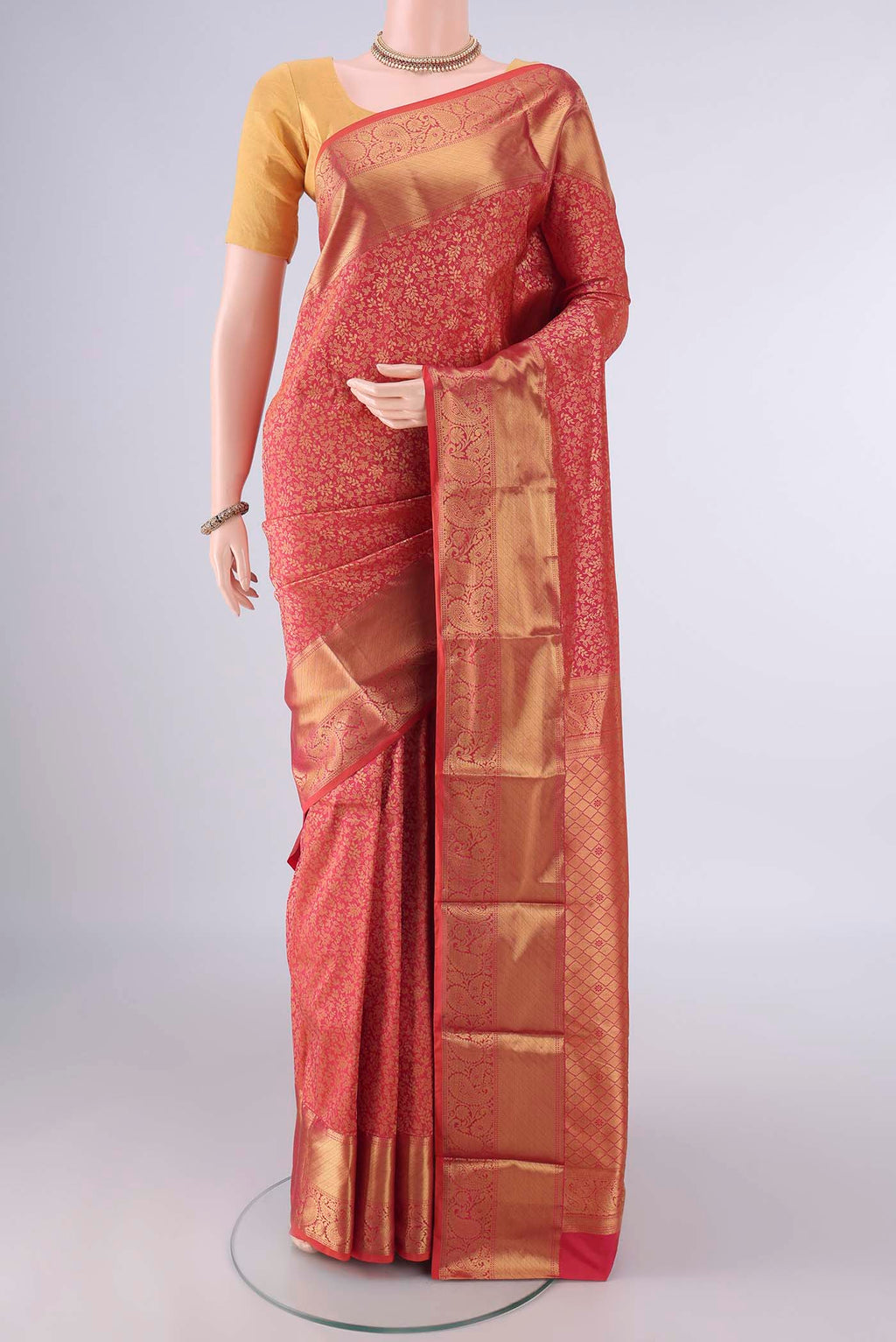 Pure Silk Coral Kanjivaram Saree with Zari Brocade on the body and Zari Border.  displayed on a mannequin