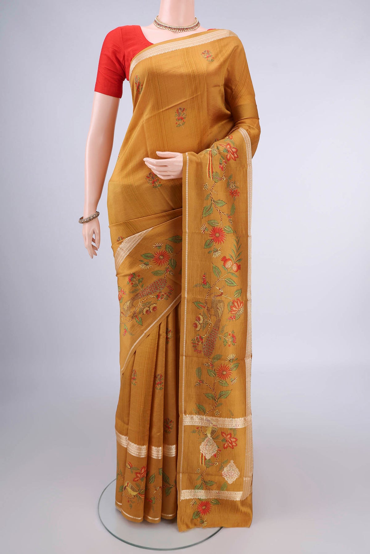 Pure Silk Mustard Printed Saree with Printed design on the body and Thread Border.  displayed on a mannequin