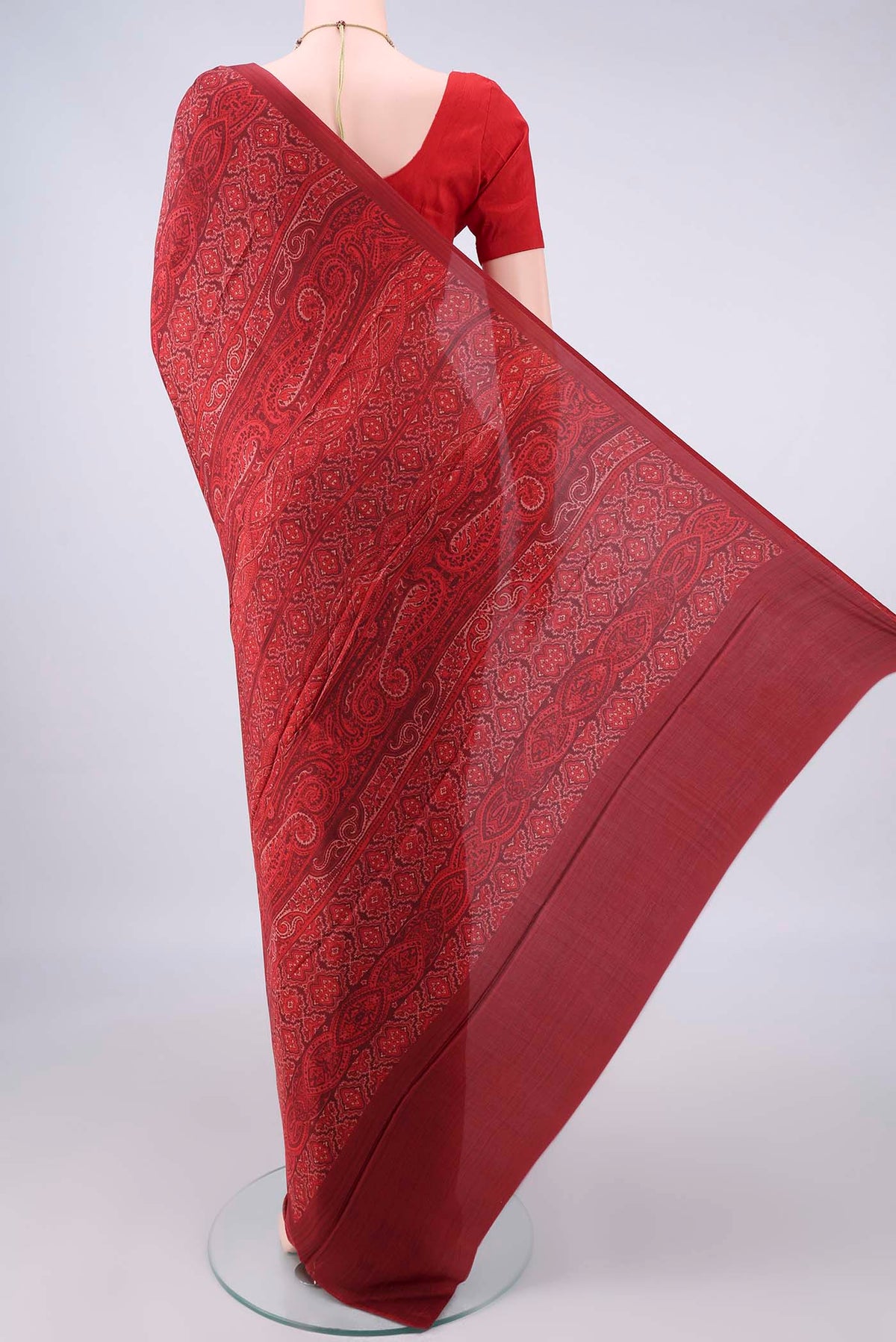 Flat view of Pure Silk Red Printed Saree with Printed design on the body and Plain Border. 