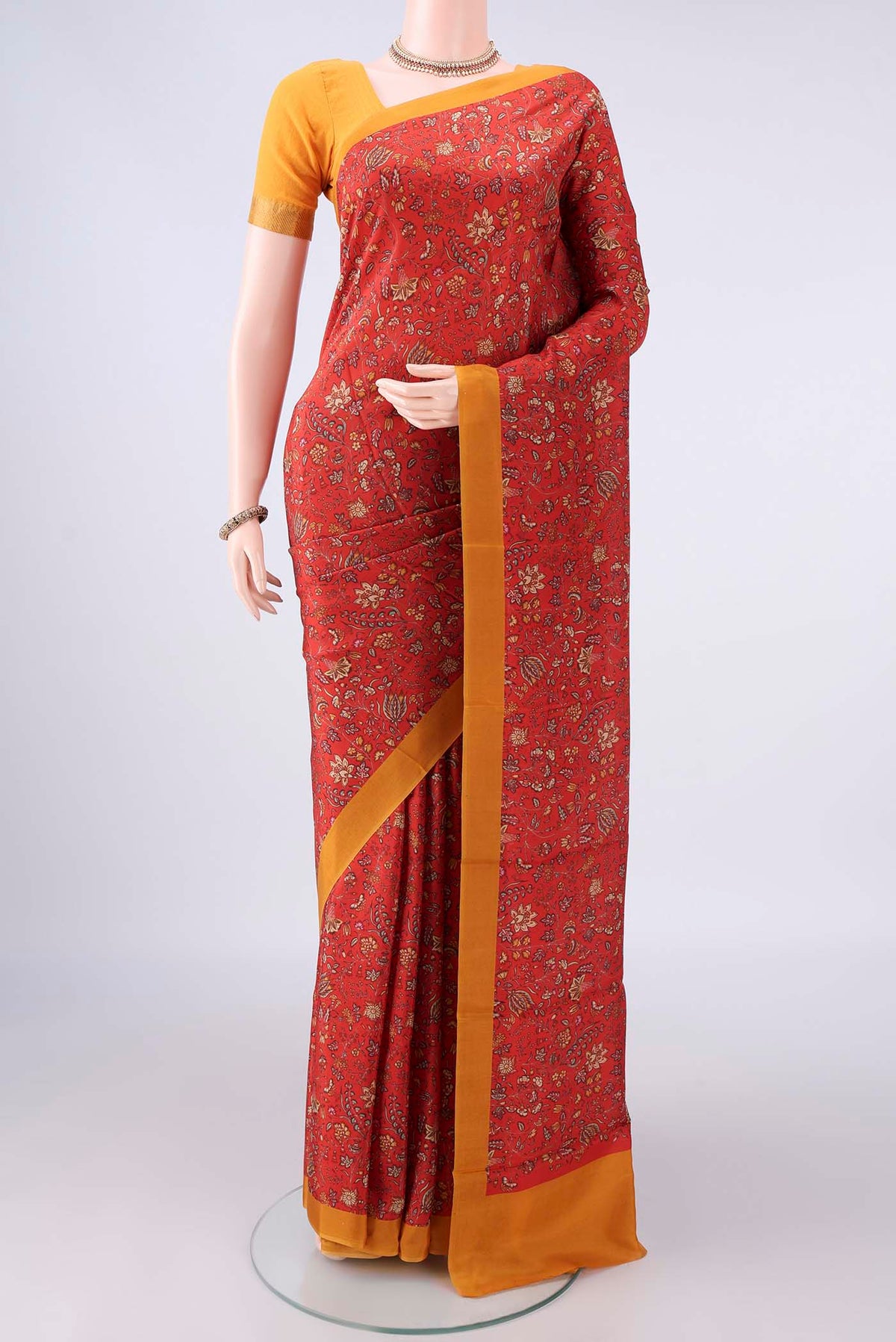 Pure Silk Orange Printed Saree with Printed design on the body and Plain Border.  displayed on a mannequin