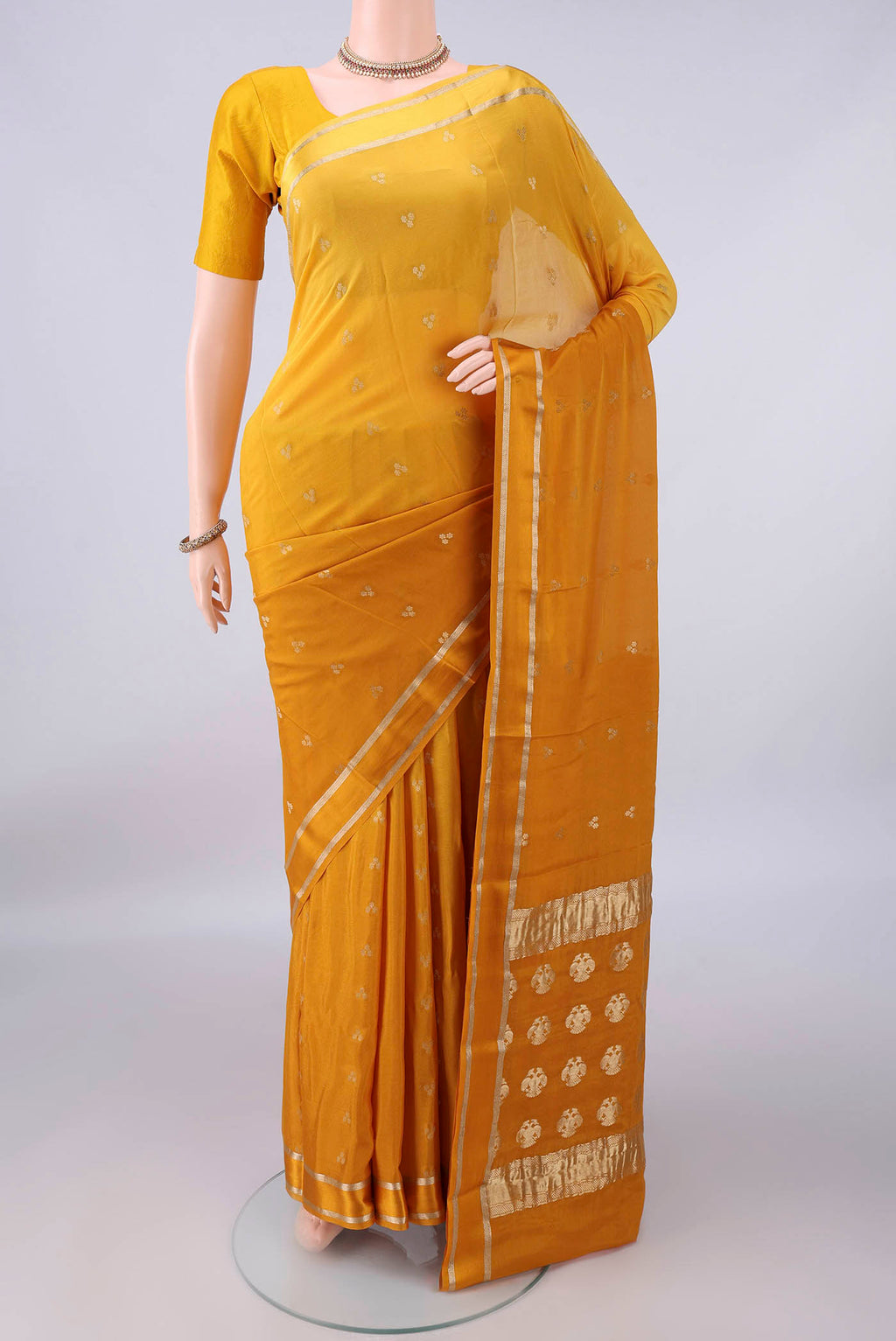 Mustard Mysore Crepe Saree with Zari Butta on the body and Zari Border.  displayed on a mannequin