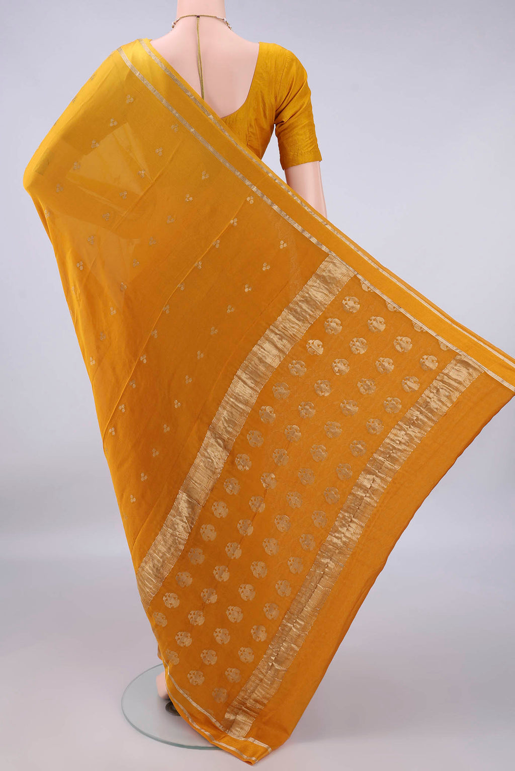 Flat view of Mustard Mysore Crepe Saree with Zari Butta on the body and Zari Border. 