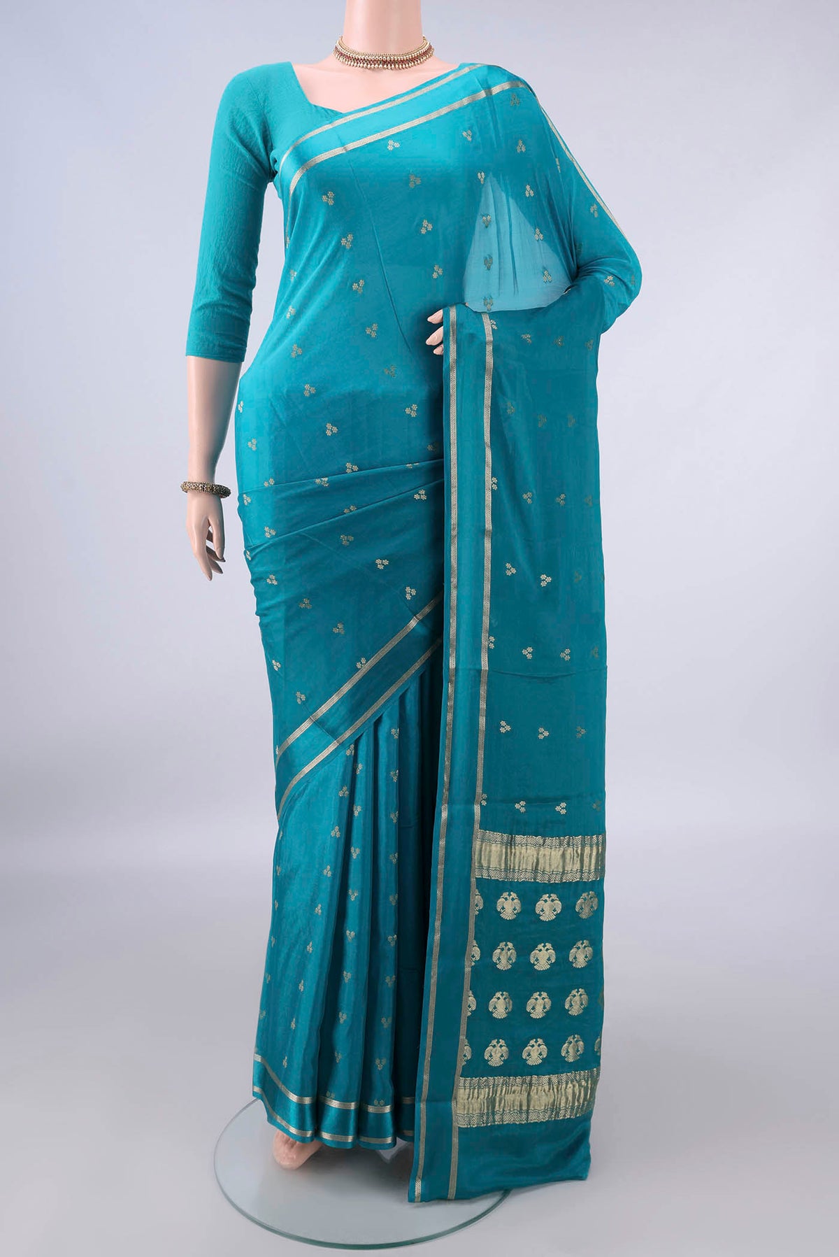 Turquoise Mysore Crepe Saree with Zari Butta on the body and Zari Border.  displayed on a mannequin