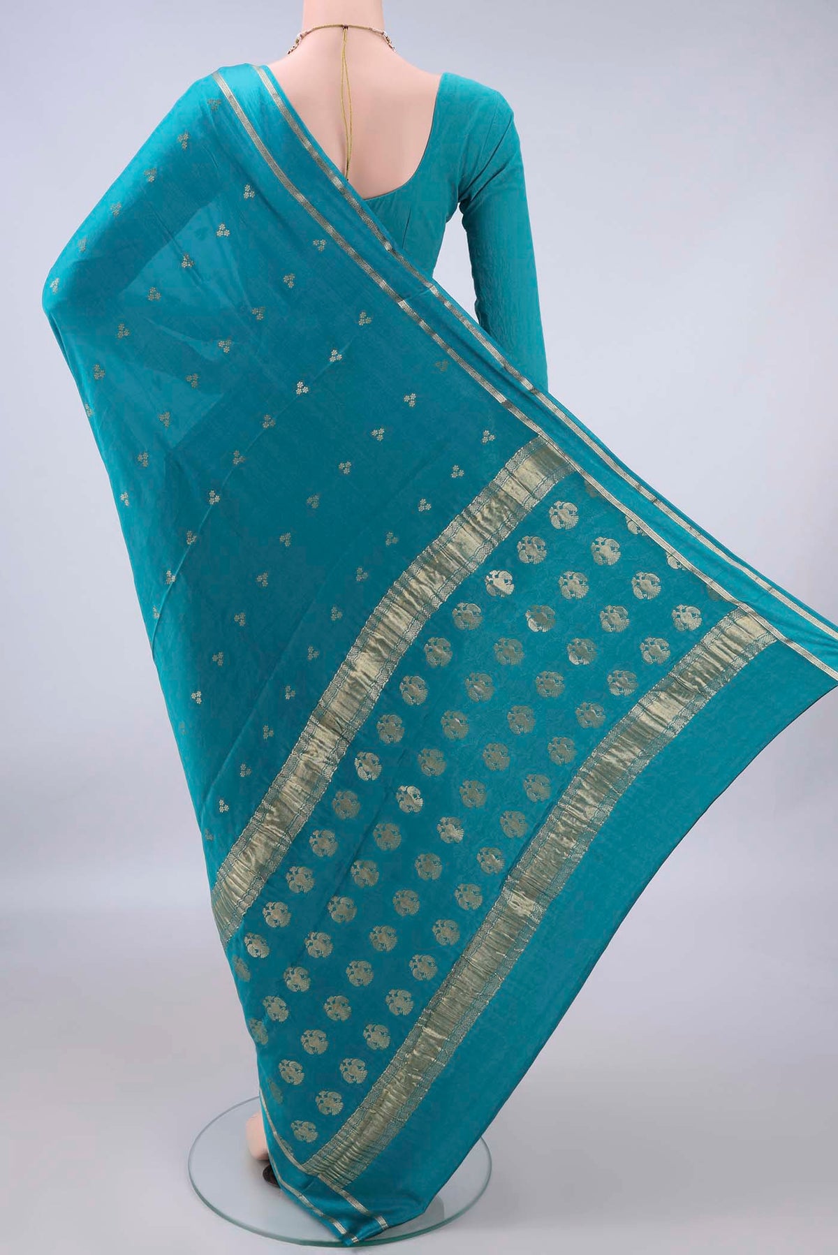 Flat view of Turquoise Mysore Crepe Saree with Zari Butta on the body and Zari Border. 