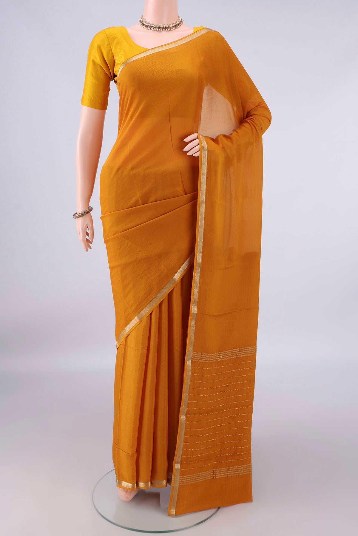 Mustard Mysore Chiffon Saree with Plain Body and Zari Border.  displayed on a mannequin
