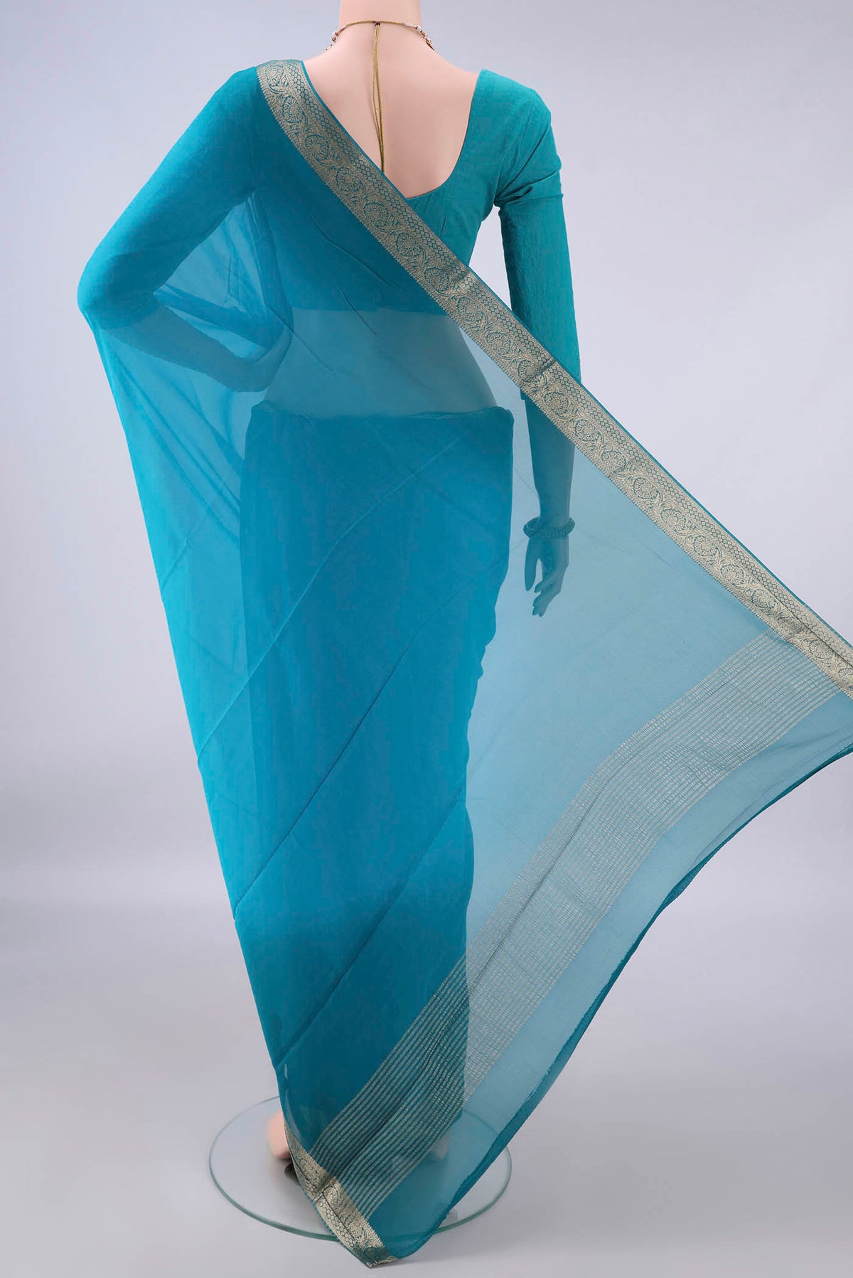 Flat view of Blue Mysore Georgette Saree with Plain Body and Zari Border. 