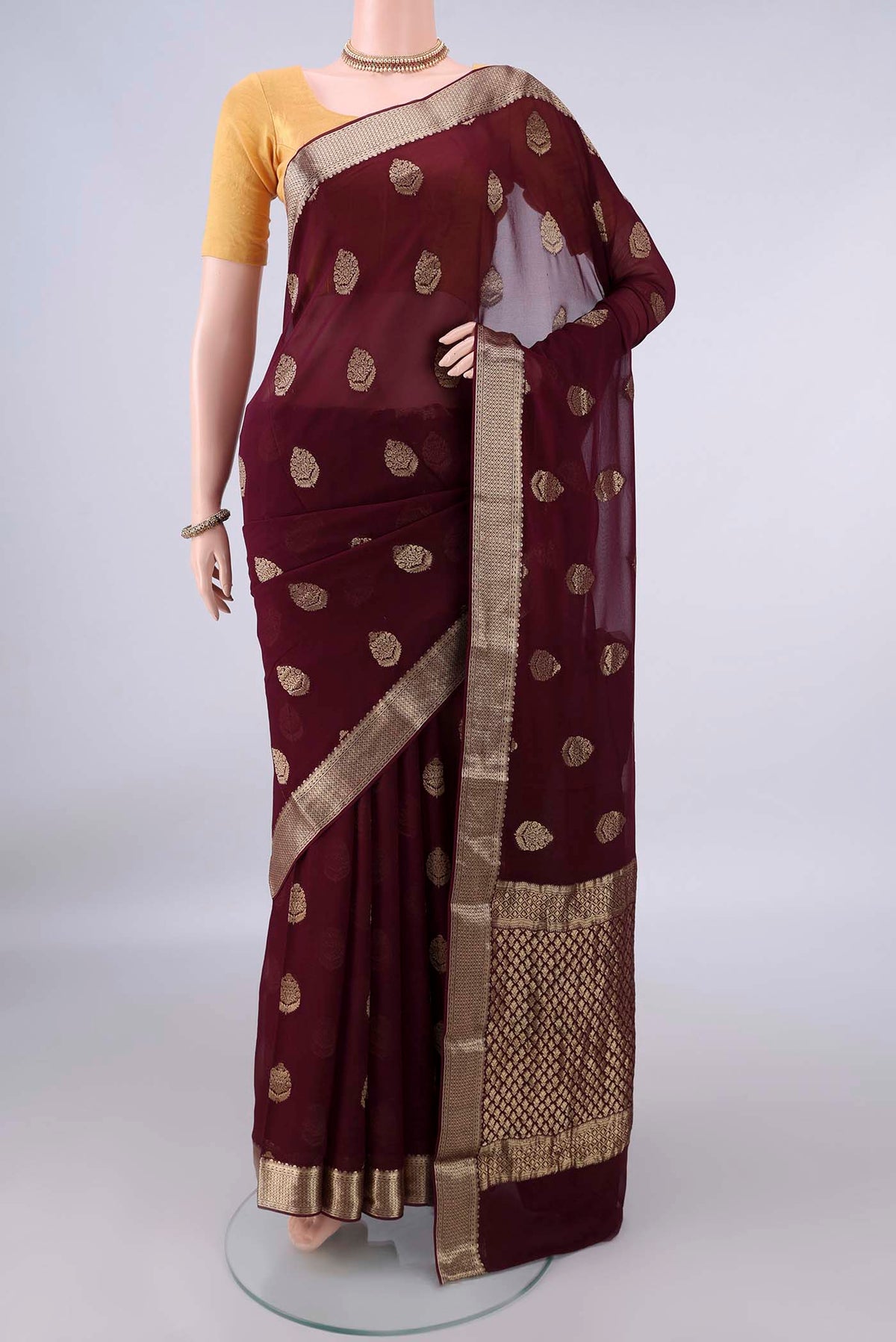 Maroon Mysore Georgette Saree with Zari Butta on the body and Zari Border.  displayed on a mannequin