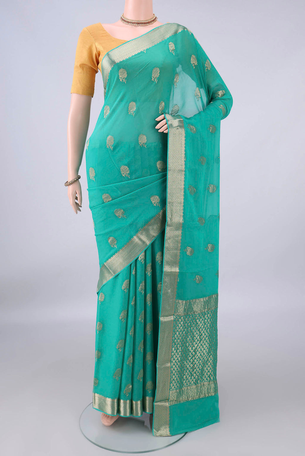 Turquoise Mysore Crepe Saree with Zari Butta on the body and Zari Border.  displayed on a mannequin
