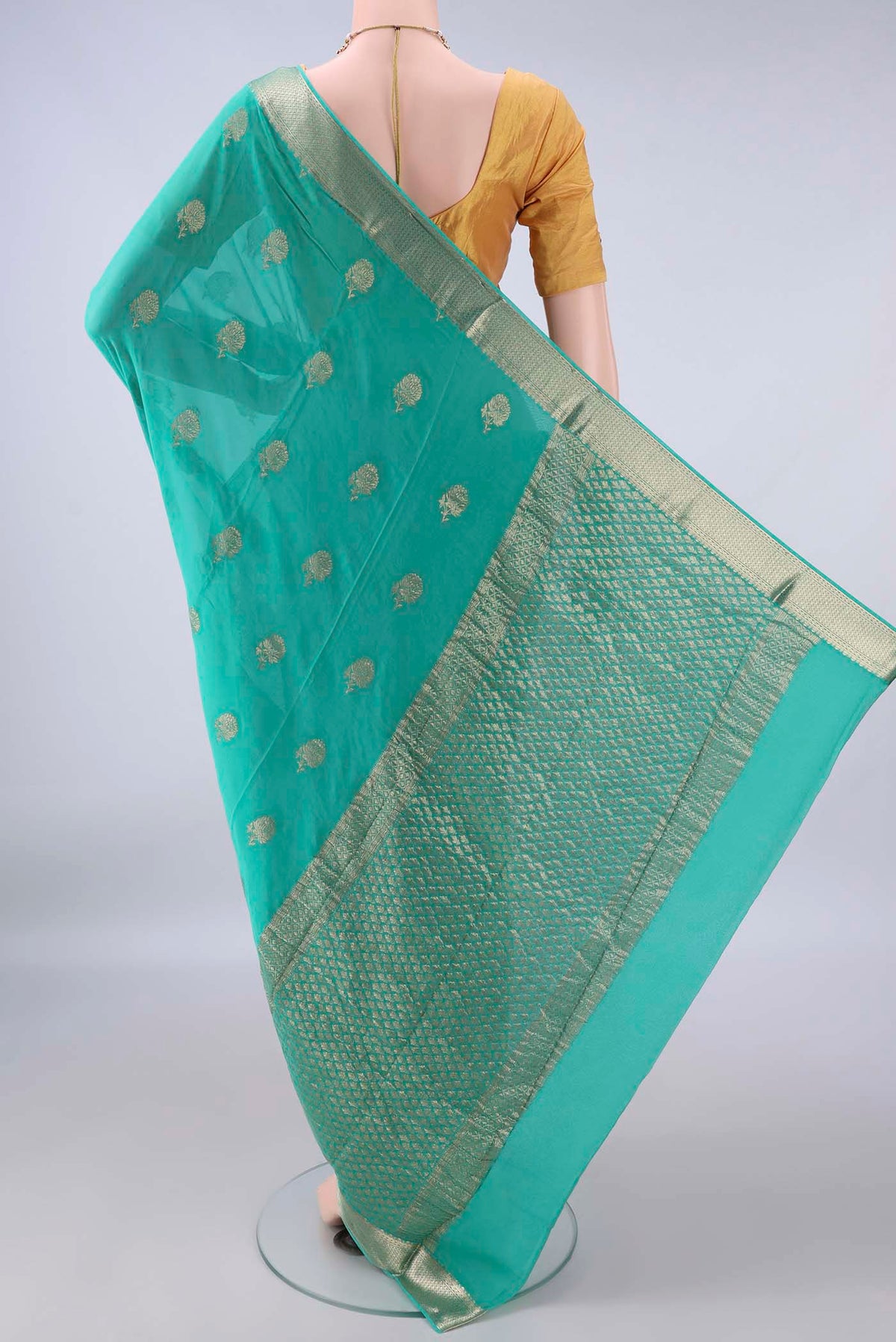 Flat view of Turquoise Mysore Crepe Saree with Zari Butta on the body and Zari Border. 